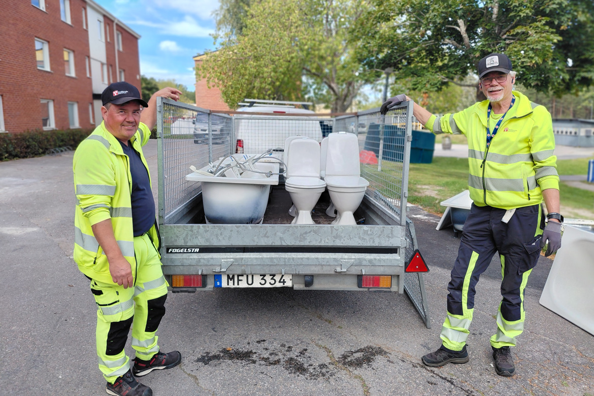 Bilden visar två anställda från Byggåterbruket som hämtar badrumsinredning från en stamrenovering